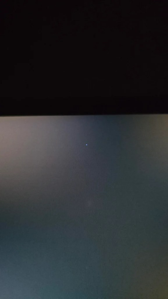 a single dead pixel in white near the top edge of a monitor