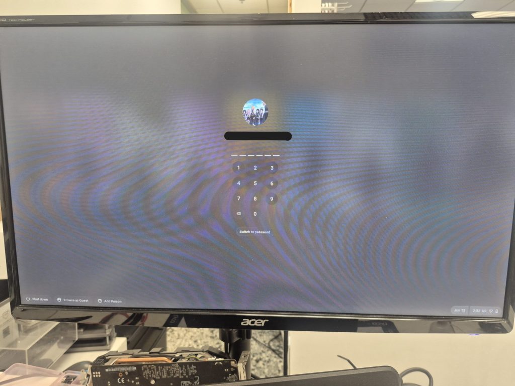 Chromebook powering on after liquid spill cleanup showing sign in page.